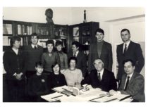 Prof. R. Baltrušio vadovaujamos Organinės chemijos laboratorijos augimo reguliatorių ir polimerų stabilizatorių sintezės mokslo grupė, 1985 m. gruodžio 22 d. Sėdi (iš kairės) lab. K. Stačiokienė, dr. V. Amankavičienė, dr. A. Machtejeva, prof. R. Baltrušis, dr. Z. J.Beresnevičius. Stovi: dr. V.Mickevičius, lab. V. Raudeliūnas, lab. R. Gribauskaitė, lab. J. Bylinskaitė, inž. K.Rutkauskas, inž. R. Kublickas, aspirantas inž. V. Viliūnas. (Ant knygų spintos – prof. A. Purėno biustas)